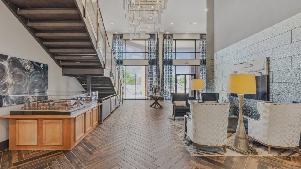 the lobby of a hotel with a staircase and wood floors at The Steelyard Apartments